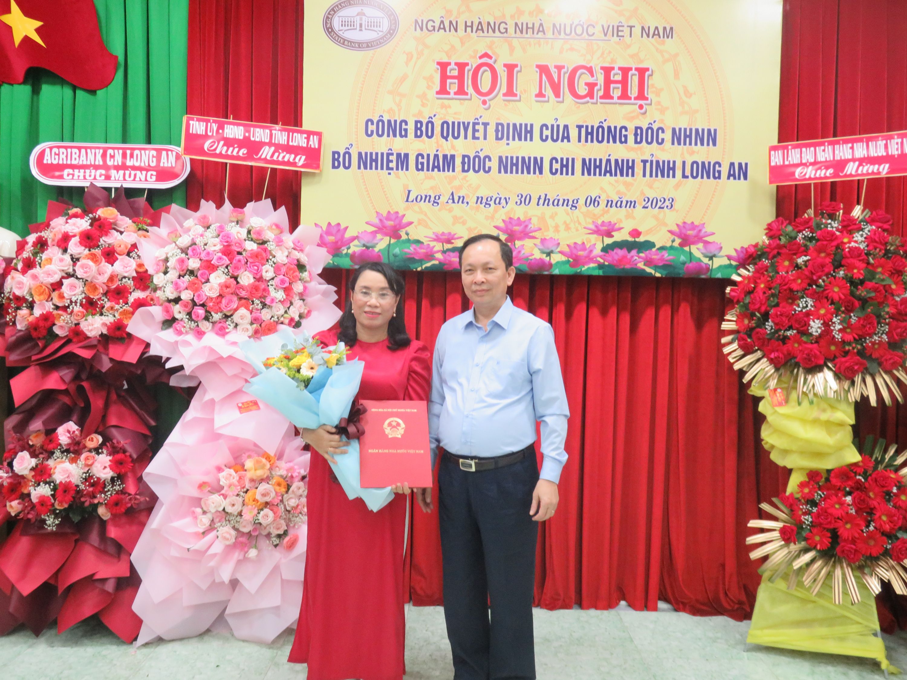 Phó Thống đốc Thường trực NHNN - Đào Minh Tú trao quyết định bổ nhiệm chức vụ Giám đốc NHNN chi nhánh tỉnh Long An cho bà Lê Thị Mỹ Hiền